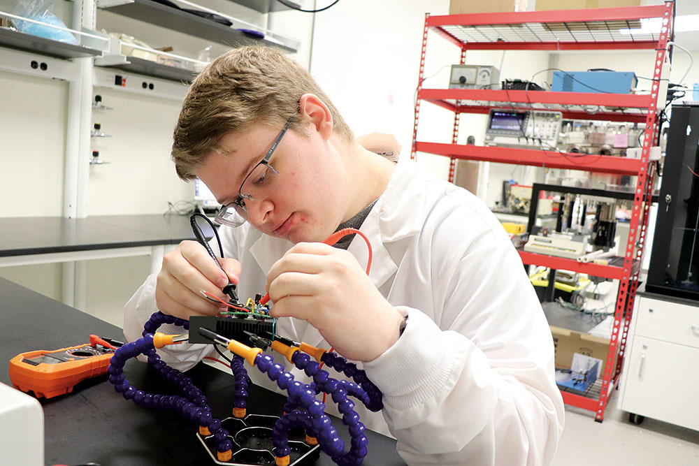 Jacob Clark works on a small robot.