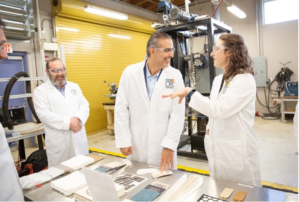 UT MSE PhD student Cece Grubb explains her dissertation work on bio-based paneling for automobiles to help Volkswagen meet their goals of a 100% recyclable vehicle to Pablo Di Si, President and CEO of Volkswagen Group of America. Cece's advisor, Prof. David Harper of the Center for Renewable Carbon, looks on.